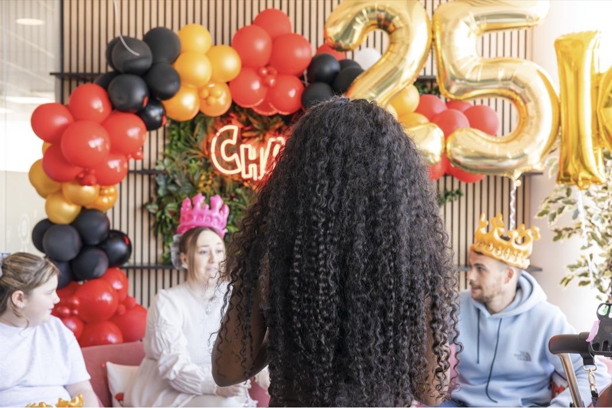 £25,000 winner celebration at Chaotic HQ with gold balloons, red and black balloon display, and winners wearing crowns
