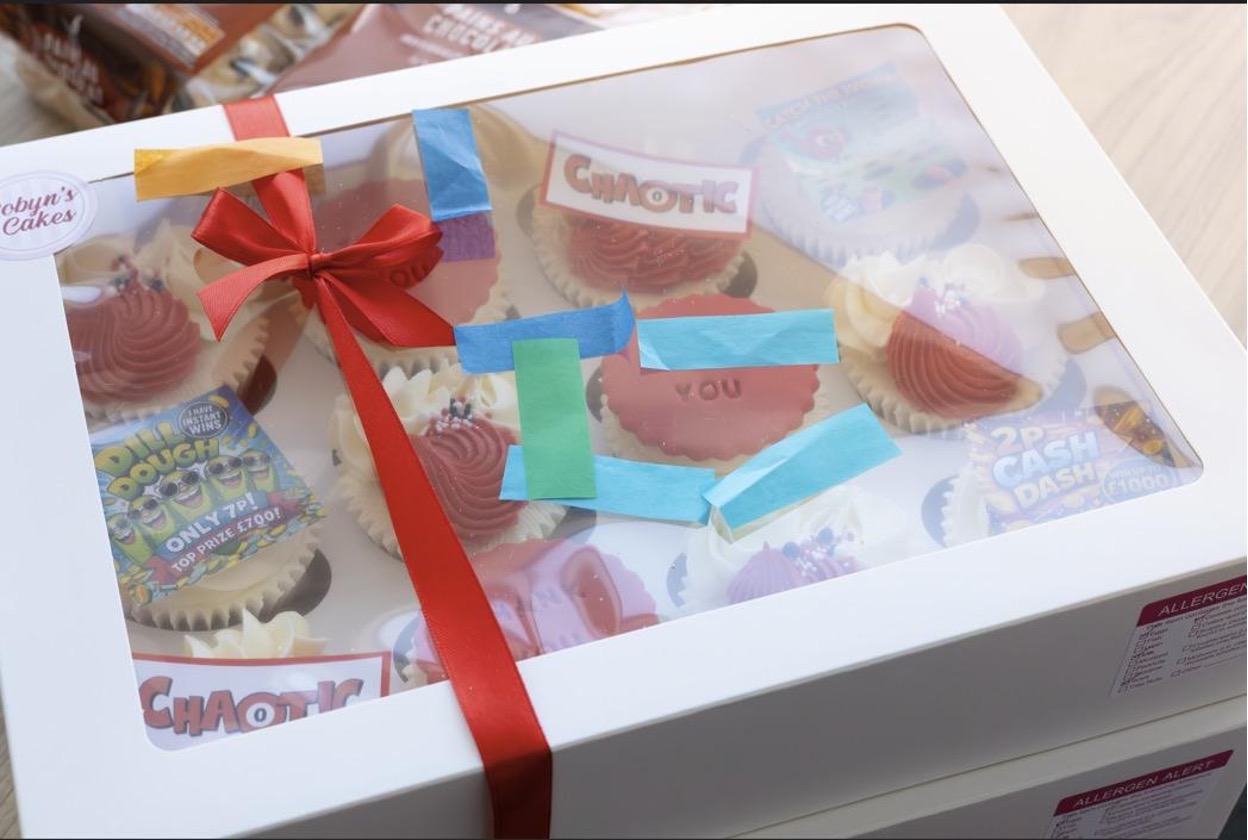 Gift box of cupcakes with a red ribbon and Chaotic branding, presented during a £25,000 winner celebration